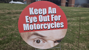 Keep An Eye Out For Motorcycles - roadside sign with Tim Misny's eye raise.